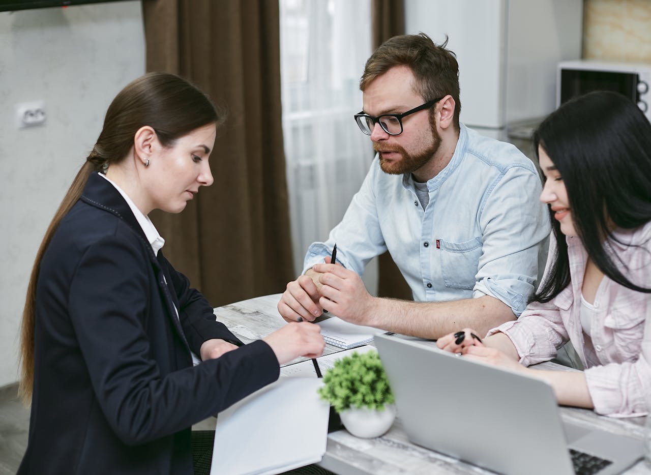 Services A couple discusses financial documents with their advisor, highlighting investment strategies.
