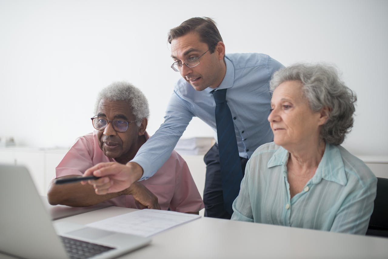 Services A business consultant explaining financial options to senior clients, using a laptop for illustration.
