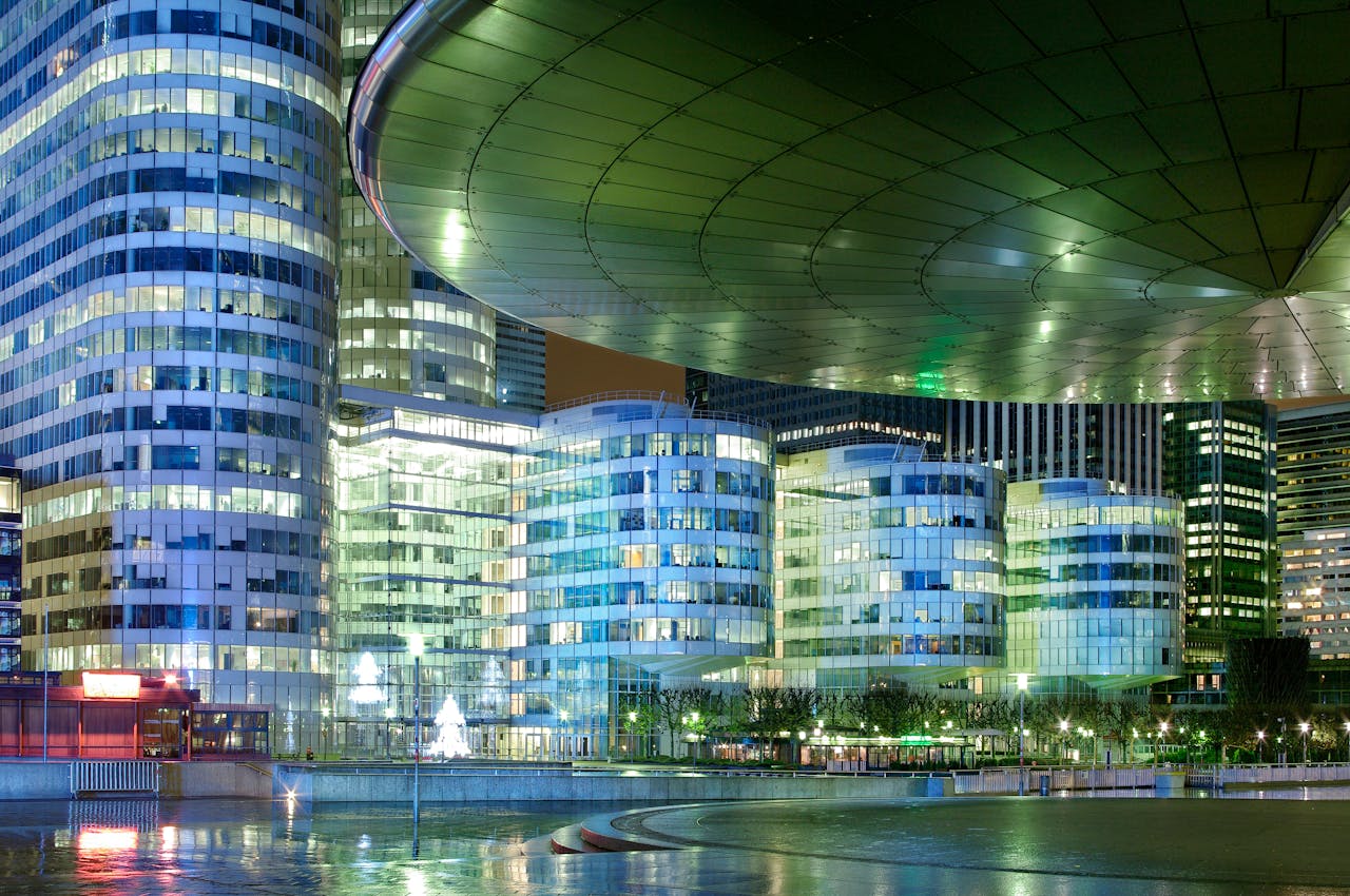 Services Illuminated modern skyscrapers in Paris, showcasing urban architecture at night.